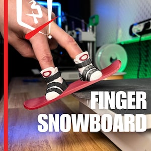 Può includere: Un piccolo snowboard rosso per le dita con stivali neri e bianchi. L'immagine include il testo "FINGER SNOWBOARD" e il logo "PLASTIC 3D".