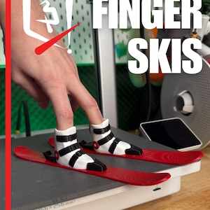 May include: Red finger skis with black and white boots, designed to fit on fingers. The image features the text "FINGER SKIS" in white. The image also includes the text "PLASTIC3D" and measurements of 256 x 256 x 256 mm.