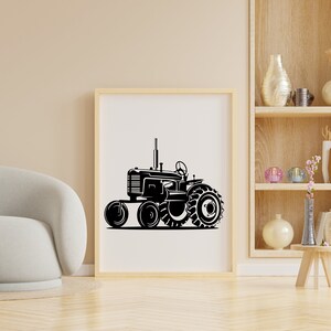 Op de afbeelding: Een zwart-witte illustratie van een vintage tractor met grote wielen. De tractor staat op een witte achtergrond en is ingelijst in een houten lijst.
