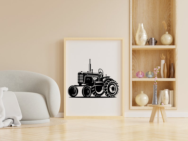 Op de afbeelding: Een zwart-witte illustratie van een vintage tractor met grote wielen. De tractor staat op een witte achtergrond en is ingelijst in een houten lijst.