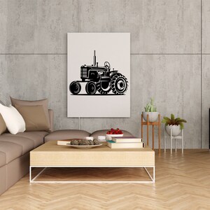 Op de afbeelding: Een zwart-witte illustratie van een vintage tractor op een witte canvas print. De print hangt aan een grijze muur in een woonkamer.