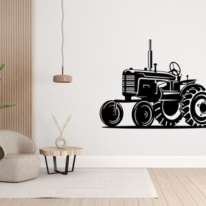 Op de afbeelding: Zwart-witte silhouet van een vintage tractor met grote wielen. De tractor is naar rechts gericht en staat op een witte achtergrond.