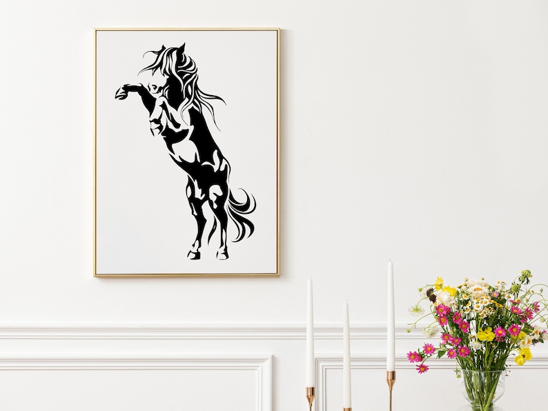 Op de afbeelding: Zwart-witte silhouet van een paard dat op zijn achterpoten staat met zijn manen in de wind. Het paard is ingelijst in een gouden lijst.