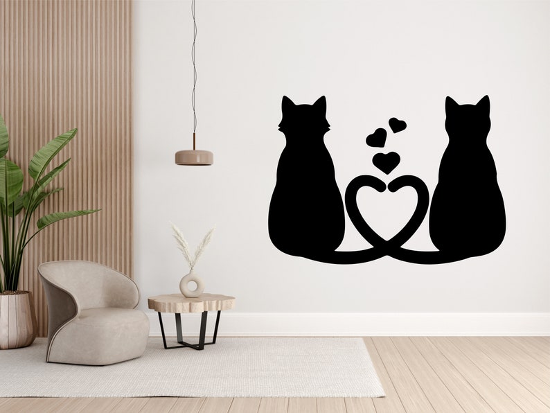 May include: Black silhouette of two cats with their tails intertwined to form a heart shape. The cats are facing away from each other, with their heads tilted slightly. There are small hearts floating above the cats.