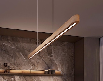 May include: A linear pendant light fixture featuring a long, curved wooden frame with a central integrated LED light strip. The fixture is suspended from the ceiling by two thin, vertical wires, showcasing a natural wood grain finish.