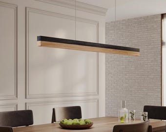 May include: A linear pendant light fixture suspended from the ceiling, featuring a long, rectangular design with a dark charcoal top section and a natural light-toned wood bottom section, hanging horizontally above a dining table.