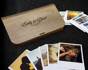 May include: A wooden box with a personalized inscription "Emily & David 24.05.2015" and a stack of instant photos inside.