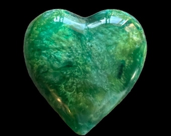 May include: A green heart-shaped resin paperweight with swirls of white and green.