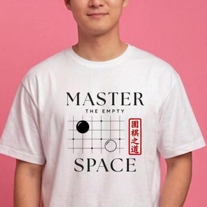 Pode incluir: Uma t-shirt branca de manga curta com uma impressão gráfica preta de uma grelha de jogo Go com uma pedra preta e uma branca. O texto diz MASTER THE EMPTY SPACE com um carimbo retangular vermelho contendo caracteres asiáticos.