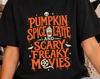 Könnte beinhalten: Ein schwarzes Kurzarm-T-Shirt mit orangefarbenem und weißem Grafiktext, der PUMPKIN SPICE LATTE AND SCARY FREAKY MOVIES lautet. Das Design enthält einen kleinen Totenkopf, einen Kaffeebecher mit Kürbisgesicht, zwei Fledermäuse und ein Filmrollen-Symbol.