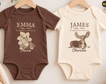 Könnte beinhalten: Zwei kurzärmelige Babybodys an Holzkleiderbügeln. Der braune Body zeigt den Namen EMMA, den Text Handpicked in heaven by und den Namen Flora mit einer Hundegrafik. Der naturfarbene Body zeigt JAMES, Handpicked in heaven by und Charlie mit einer Hundegrafik.