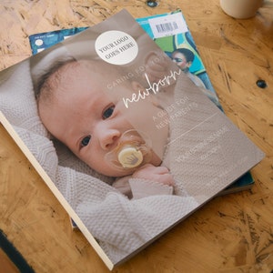 May include: A guide for new parents titled "Caring for Your Newborn". The cover features a close-up photo of a baby wearing a white knitted sweater and a pacifier. The text "Your Logo Goes Here" is in the top right corner.