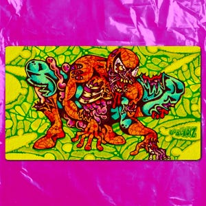 May include: A rectangular desk mat featuring a vibrant, detailed illustration of a decaying, zombie-like figure with exposed skeletal elements, rendered in shades of orange, teal, and purple against a bright, lime-green, organic-patterned background.