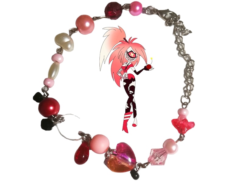 May include: A pink and red beaded bracelet with a silver chain and a heart-shaped charm. The bracelet features various beads, including pink, red, white, and clear beads.