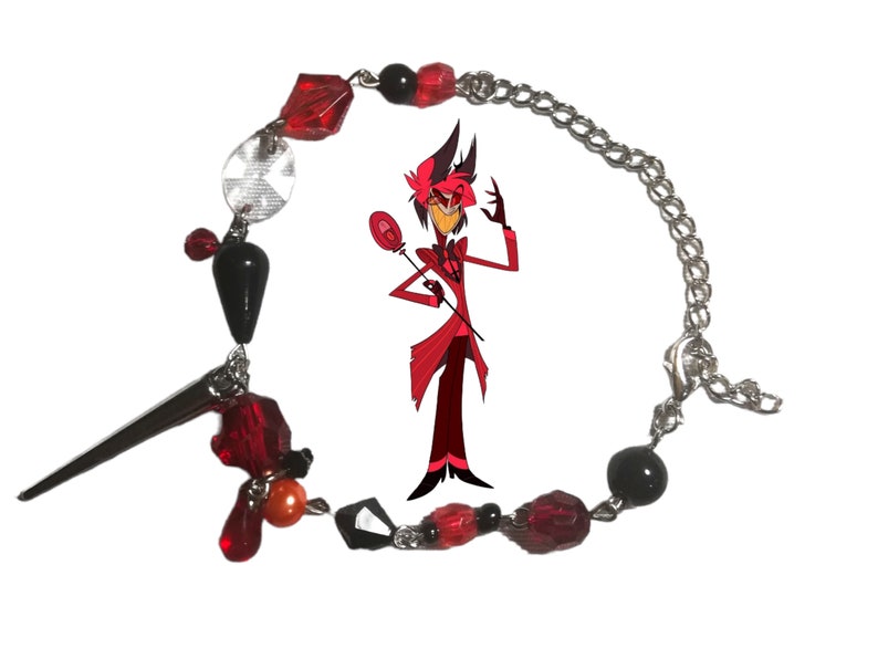May include: A red and black beaded bracelet with a silver chain and a charm of a cartoon character. The character is red with black eyes and a black top hat. The character is holding a red and black wand.