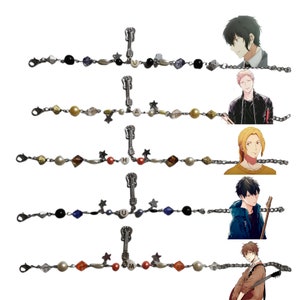 Può includere: Cinque braccialetti d'argento con ciondoli a forma di chitarra e perline con lettere che compongono la parola "HUMA". Ogni braccialetto è decorato con perline di diversi colori, tra cui nero, blu, oro, rosso e bianco.