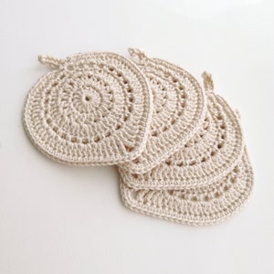 May include: Set of four crocheted beige pot holders in a heart shape.