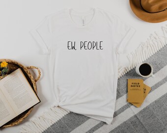 Puede incluir: Camiseta blanca con el texto "EW. PEOPLE" impreso en negro en la parte delantera.
