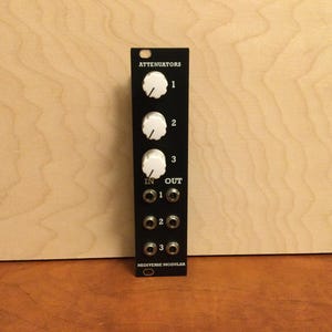 May include: A black 3-channel attenuator module with white knobs and labeled "ATTENUATORS" and "MIDIVERSE MODULAR".