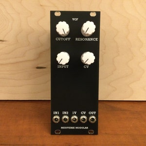 May include: Black VCF module with four knobs labeled "CUTOFF", "RESONANCE", "INPUT", and "CV".  The module has six jacks labeled "IN1", "IN2", "1V", "CV", and "OUT".  The text "MIDIVERSE MODULAR" is printed at the bottom of the module.