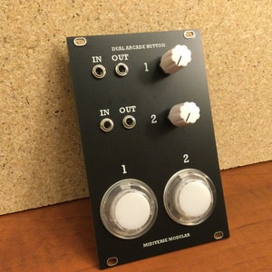 May include: Black dual arcade button module with two knobs, two sets of input and output jacks, and the text "DUAL ARCADE BUTTON" and "MIDIVERSE MODULAR".