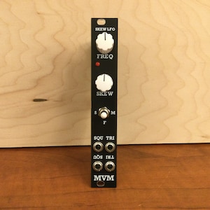 May include: Black synthesizer module with white knobs labeled "Skew LFO", "Freq", and "Skew". It has a toggle switch labeled "S, M, F" and six jacks labeled "Sou", "Tri", "Nos", "Tri", "Sou", and "Mvm".