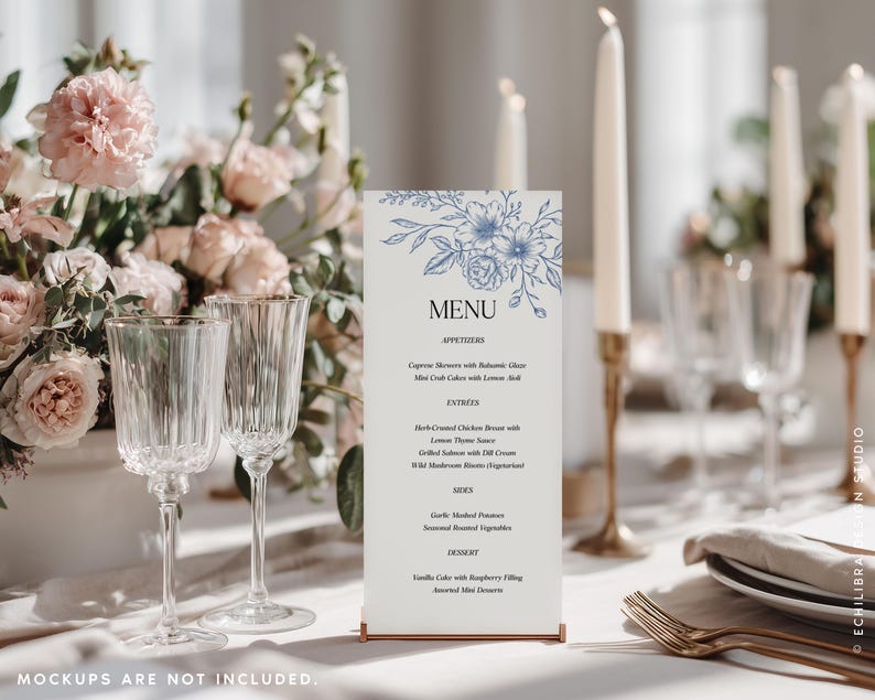 May include: A vertical rectangular menu card featuring a blue floral line art illustration at the top, the word MENU in black, and a list of food items in black text. The card is held upright by a thin metallic base on a white table setting.