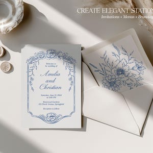 May include: A white wedding invitation card featuring blue floral illustrations and a decorative border, with the text Amelia and Christian, Saturday, June 15, 2024, at 3:00 PM, Rosewood Gardens, 123 Floral Avenue, Springfield. Includes a matching envelope.