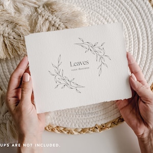 May include: A white paper with the word "Leaves" and a vector illustration of leaves. The paper is held by hands and rests on a woven placemat. The text "vector illustration" is below the word "Leaves".