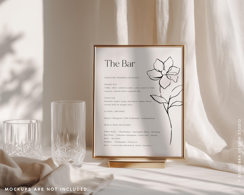 Puede incluir: Un letrero rectangular en un marco dorado con el texto The Bar, una lista de c&oacute;cteles de boda, bebidas cl&aacute;sicas y selecci&oacute;n de cervezas y vinos, acompa&ntilde;ado de un dibujo lineal negro de una flor sobre un fondo blanco.