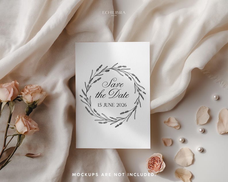 May include: A white card with the text "Save the Date" inside a floral wreath. The date "15 JUNE 2026" is below the text. The card is on a cream-colored surface with roses, petals, and pearls.