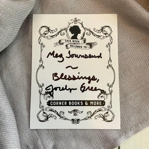 May include: A white bookplate with a black and white ornate border. The text "This book belongs to" is printed in black. The bookplate is signed "Meg Townsend" and "Blessings,  Jodi Greer". The text "Corner Books & More" is printed in black at the bottom.