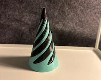 May include: A teal blue cone with black spiral lines. The cone is made of plastic and is about 3 inches tall.