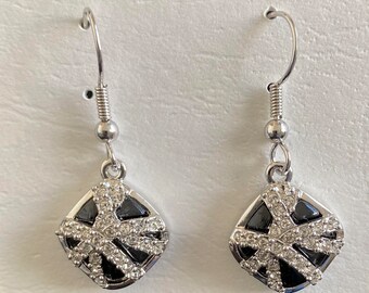 May include: A pair of silver dangle earrings with a black and white gift box design. The gift box is decorated with rhinestones.
