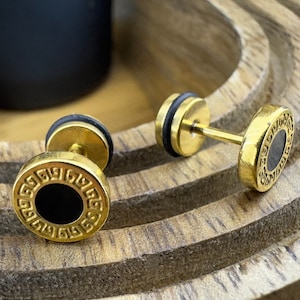 Op de afbeelding: Een paar gouden oorbellen met zwarte accenten. De oorbellen hebben een rond ontwerp met een Grieks sleutelpatroon.