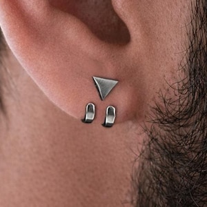 Puede incluir: Un juego de tres tazas de cerámica con un acabado mate moteado. Cada taza presenta un color diferente: azul claro, crema y gris. Las tazas tienen un diseño simple y moderno y un asa cómoda.