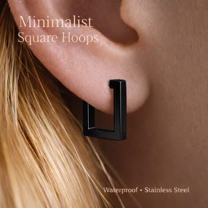 Op de afbeelding: Close-up van een zwarte vierkante oorring. De oorring is gemaakt van roestvrij staal en is waterdicht. De tekst "Minimalist Square Hoops" staat in de linkerbovenhoek. De tekst "Waterproof • Stainless Steel" staat onderaan.