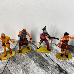 May include: Set of four plastic toy figures, depicting historical characters. The figures are painted in various colours, including brown, yellow, blue, green, and red. The figures are standing on yellow plastic bases.