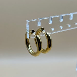 May include: A pair of gold hoop earrings. The earrings are simple and elegant, and they would be a great addition to any jewelry collection.