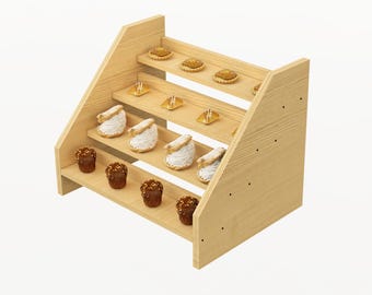 Puede incluir: Un expositor de madera de cuatro niveles con cuatro estantes, que muestra una variedad de pasteles y pequeños pasteles. El expositor está hecho de madera clara y tiene un acabado natural. Los pasteles incluyen tartas pequeñas, profiteroles y golosinas cubiertas de chocolate.