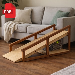 以下が含まれることがあります： 自然な仕上がりの木製スロープで、傾斜した表面とサイドレールが特徴です。スロープには、テニスボールが入った織りバスケットが付いた下の棚があります。赤いPDFアイコンが左上にあります。