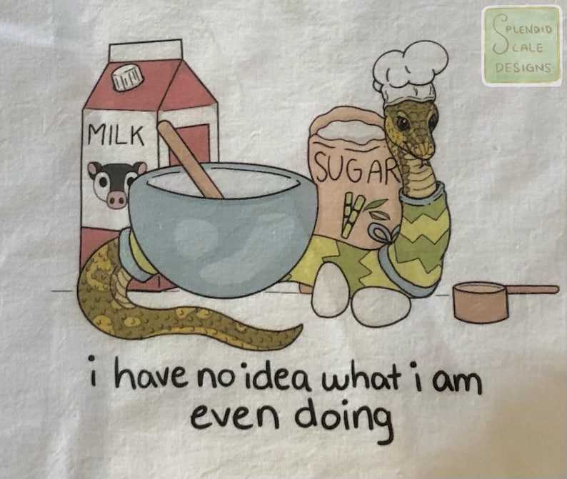 Op de afbeelding: Illustratie van een slangkok met een koksmuts, omringd door bakbenodigdheden: melkpak, suikerzak, mengkom en maatbeker. De tekst "i have no idea what i am even doing" staat onderaan.
