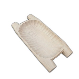 May include: A wooden serving tray with a carved design. The tray has two handles on either side.