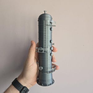 May include: A gray 3D printed model of an industrial tower with multiple levels and a ladder. The tower has a cylindrical shape with a rounded top and a flared base.