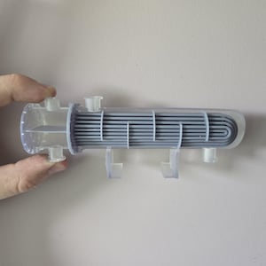 May include: A clear plastic model of a heat exchanger with a gray metal core. The model is mounted on clear plastic supports.
