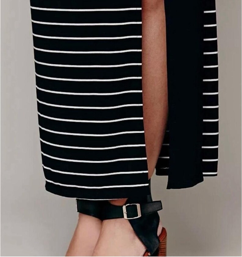 May include: A black and white striped maxi dress with a high side split. The dress is worn with black leather sandals with a buckle fastening and a block heel.