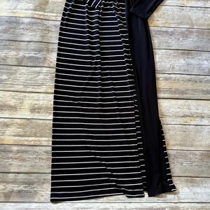 May include: A black and white striped maxi skirt with a high waist and a solid black long-sleeved top. The skirt has horizontal white stripes on a black background.