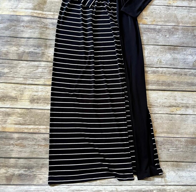 May include: A black and white striped maxi skirt with a high waist and a solid black long-sleeved top. The skirt has horizontal white stripes on a black background.