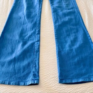 Pode incluir: Jeans flare azul claro. As cal&ccedil;as de ganga t&ecirc;m um design cl&aacute;ssico de cinco bolsos e uma abertura larga para as pernas. Os jeans s&atilde;o feitos de um tecido de ganga de peso m&eacute;dio e s&atilde;o adequados para uso casual.