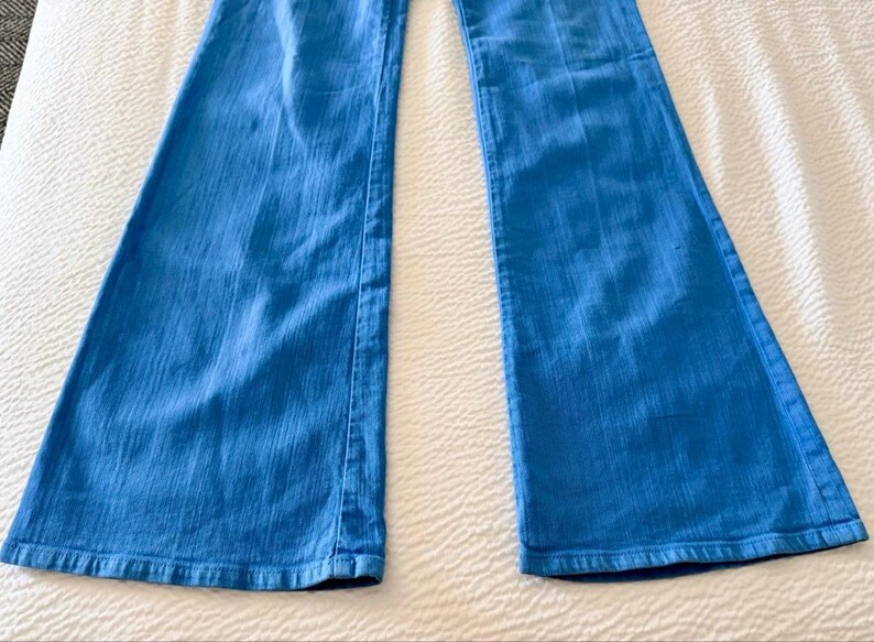 Pode incluir: Jeans flare azul claro. As cal&ccedil;as de ganga t&ecirc;m um design cl&aacute;ssico de cinco bolsos e uma abertura larga para as pernas. Os jeans s&atilde;o feitos de um tecido de ganga de peso m&eacute;dio e s&atilde;o adequados para uso casual.